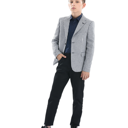 A Moustache Kids Model wearing a striped black and white Blazer He is sporting a blue Moustache Kids dressshirt underneathwith black trousers and black dress shoes