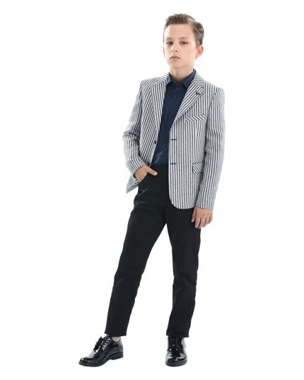 A Moustache Kids Model wearing a striped black and white Blazer He is sporting a blue Moustache Kids dressshirt underneathwith black trousers and black dress shoes