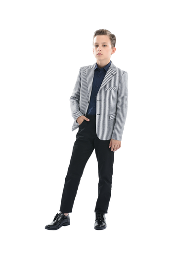 A Moustache Kids Model wearing a striped black and white Blazer He is sporting a blue Moustache Kids dressshirt underneathwith black trousers and black dress shoes